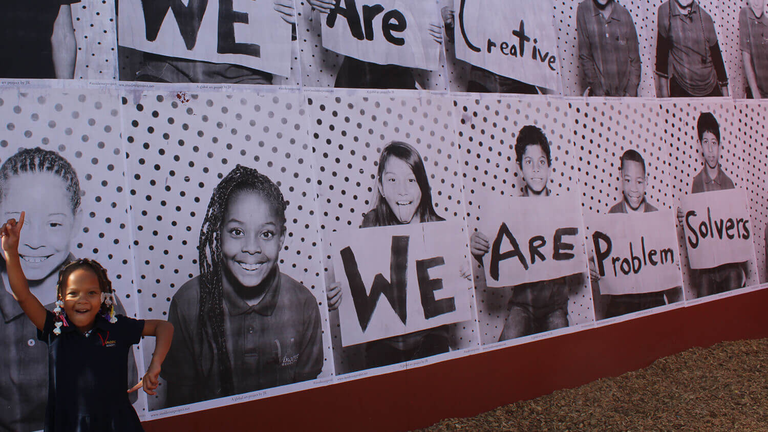 Student posing in front of a mural