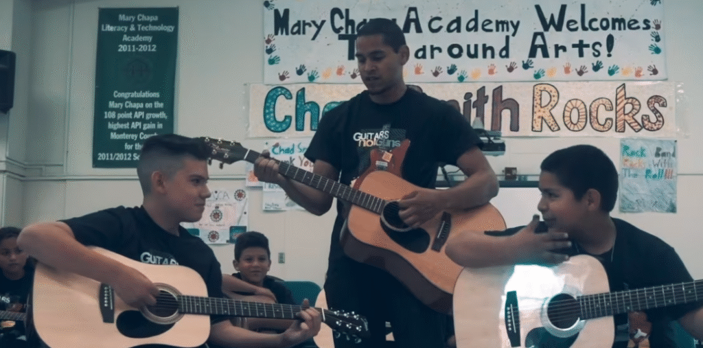 Turnaround Arts: Teacher playing guitar with students