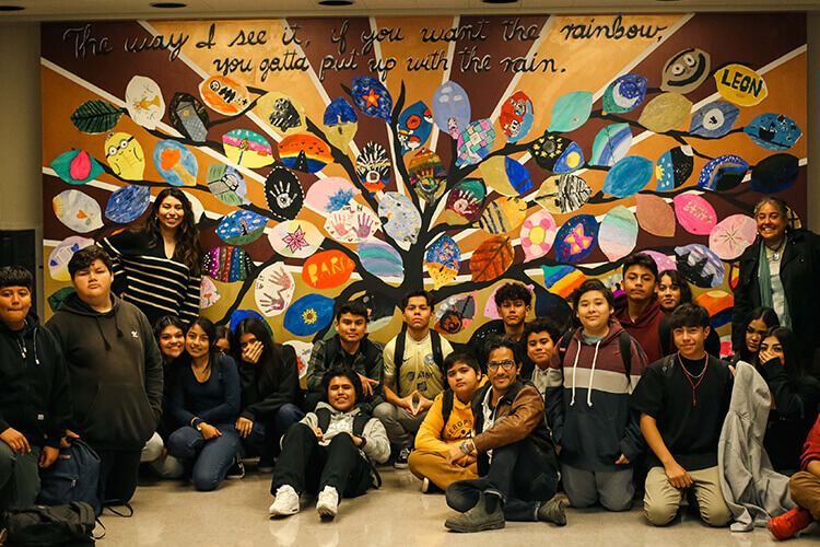 students in front of a mural