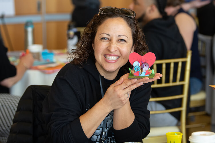 teacher posing with an art piece