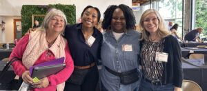 Four attendees smile at the camera